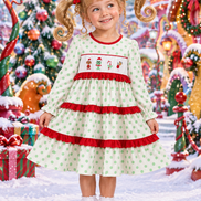 Little girl in the exact green-polka-dot Grinch-embroidered dress with a whimsical Whoville hairstyle in a magical Christmas Whoville scene