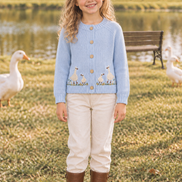 Six-year-old wearing the goose cardigan in the same farm scene